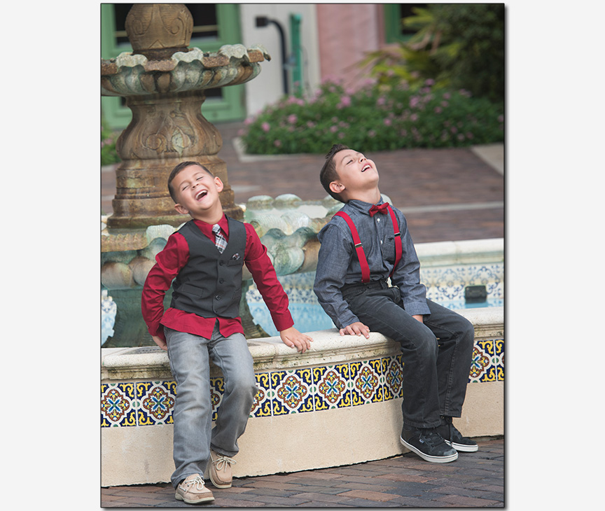 two young brothers laughing with their heads thrown back