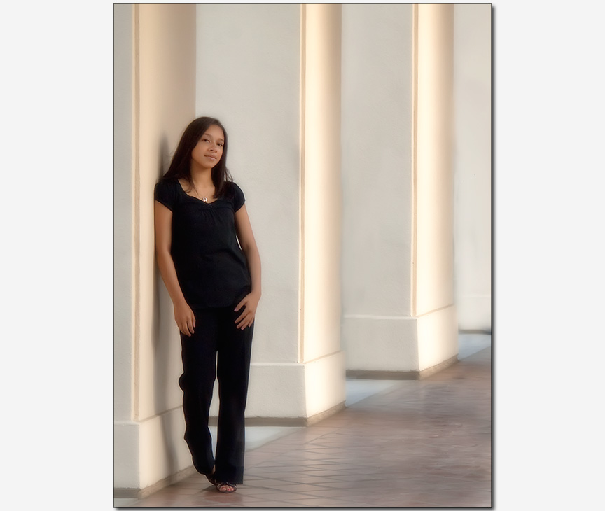 teenage girl leaning on a walkway pillar